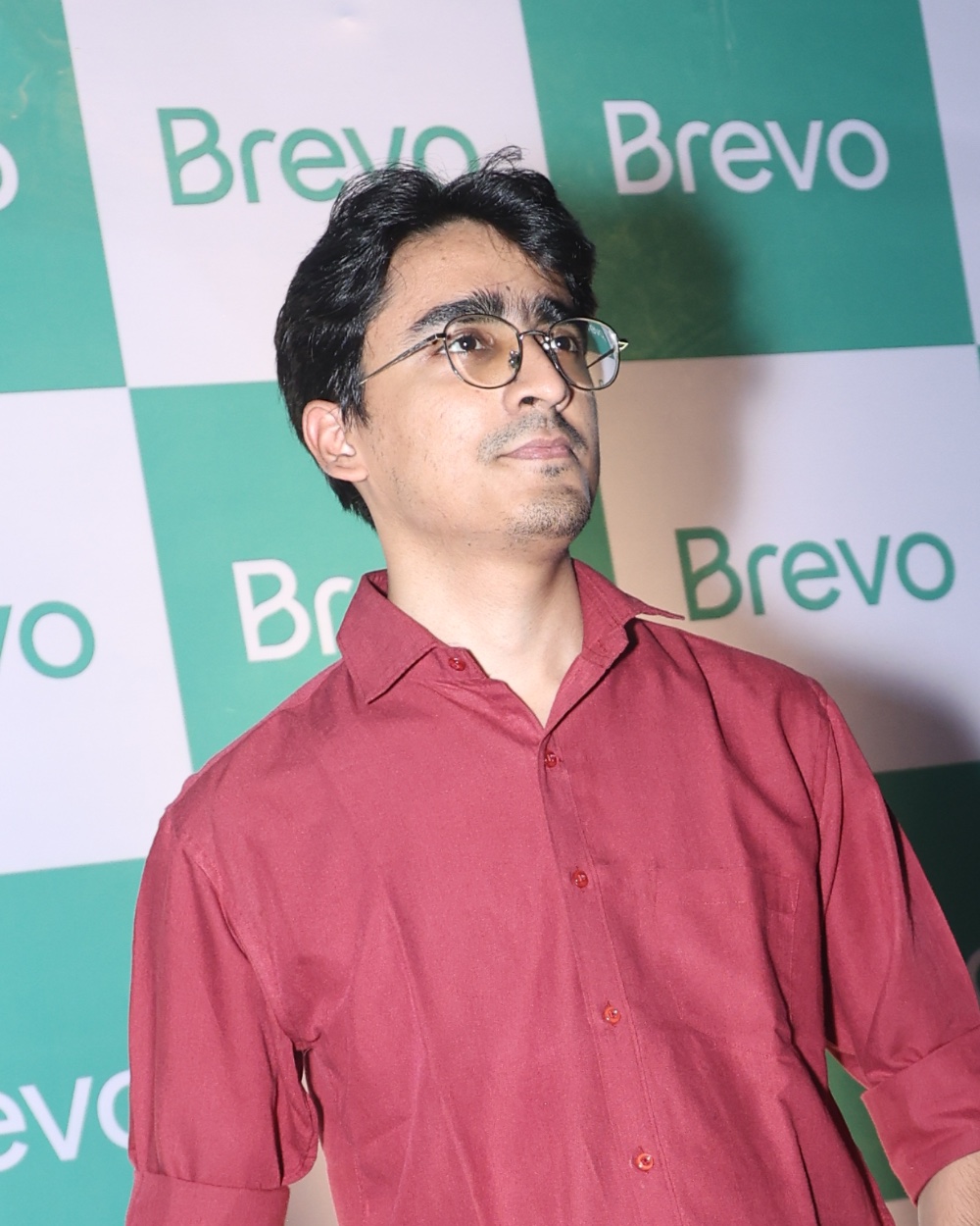 Shiva Saxena, head and shoulders, glasses, red shirt, looking off to the side
